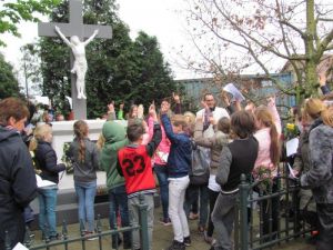 Kinderen Velddriel leggen bloemen bij het kruis