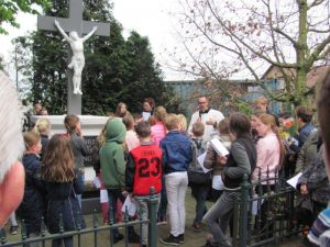 Kinderen Velddriel leggen bloemen bij het kruis